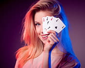 An image of a live blackjack dealer hiding behind her cards