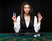 An image of a live casino dealer holding up her chips